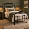 [Black | Single] Angled view showing curved headboard and footboard, bedding, knitted throw, dome lamps, and framed art.