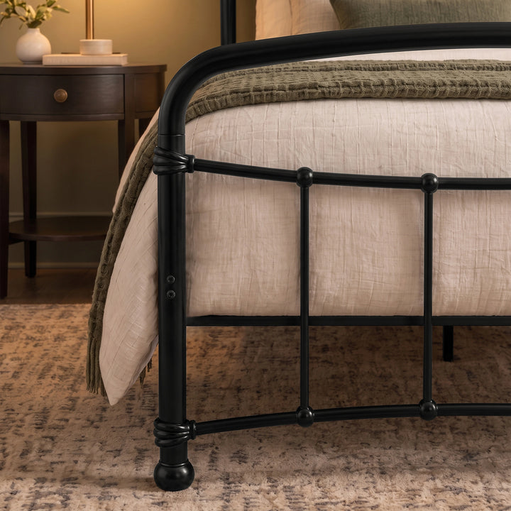[Black | Single] Footboard close-up showing curved rail, ball details, wrapped joints, exposed bolts, bedding, and throw.