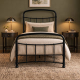 [Black | Single] Front view showing curved rails, ball details, layered pillows, knitted throw, bedside tables, and lamps.