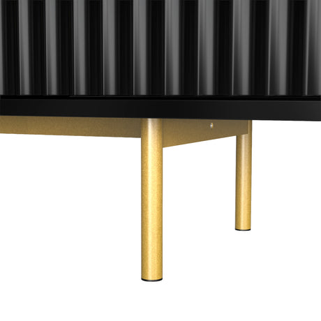 Black TV entertainment unit with slim gold metal legs and fluted textures, showcasing an elevated modern furniture design.