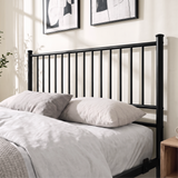 [Black | Double] Black double bed close-up view of tall vertical-bar metal headboard behind layered cream pillows and bedding
