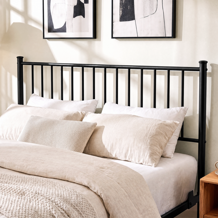 [Black | Double] Black double bed close-up view of tall vertical-bar metal headboard behind layered cream pillows and bedding
