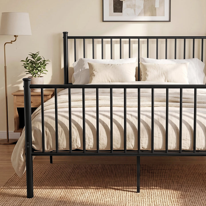 [Black | King] Metal bed front close-up of bar headboard and footboard, white bedding, centre leg, plant and bedside table.