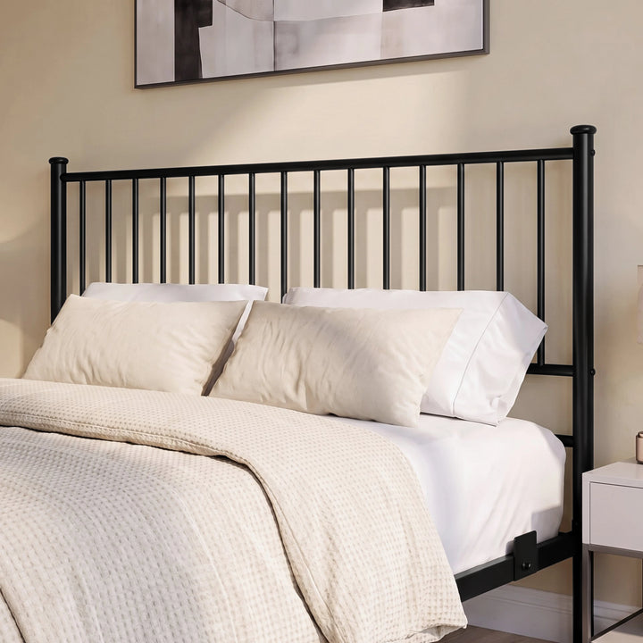 [Black | King] Metal bed close-up view of tall vertical-bar headboard with white pillows & black-and-white abstract wall art.