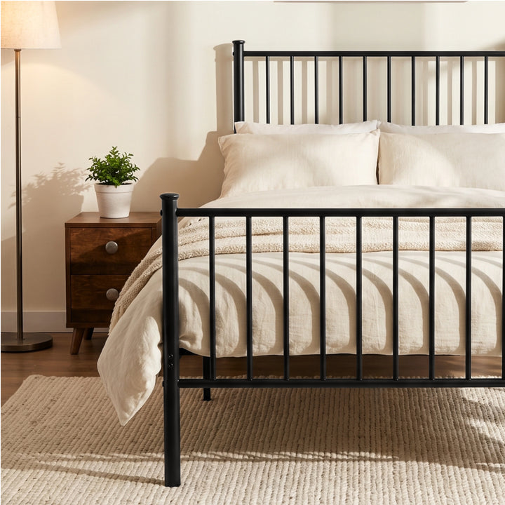 [Black | Single] Metal bed close-up of tall bar headboard with cream-white pillows, wooden bedside table, plant and wall art.