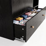 [Black] Wardrobe open drawer detail showing folded clothing, dividers, dark wood grain, metal runners, and knob handle.