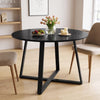 [Black Wood] Round dining table in a bright room with fruit, flowers and candles on top, with two chairs beside it.