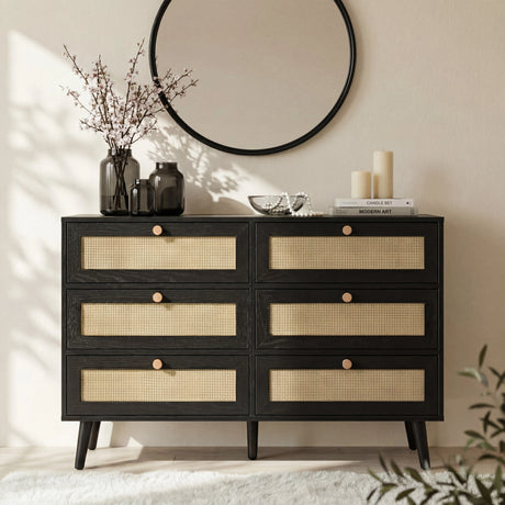 [Black] Wovena wide chest front view with six rattan cane drawer panels and dark hardwood knobs in a styled bedroom