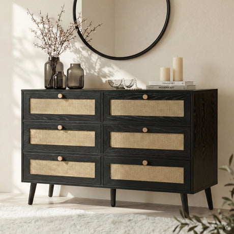 [Black] Wovena rattan wide chest three-quarter angle showing six cane mesh drawer fronts and splayed dark legs