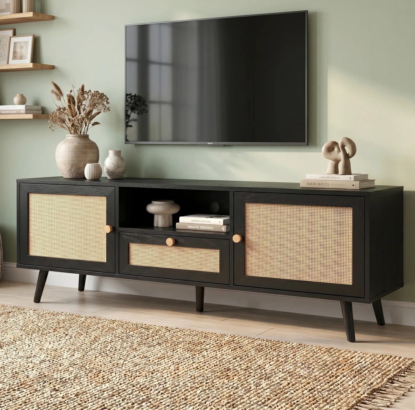 [Black] Wovena Black Rattan TV Unit with 2 Door Storage three-quarter view in sage green room with rattan door panels, central drawer and tapered black legs