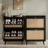 [Black] Wovena shoe cabinet shown side by side, left unit open displaying trainers on internal shelves and right unit closed with rattan panel doors in hallway