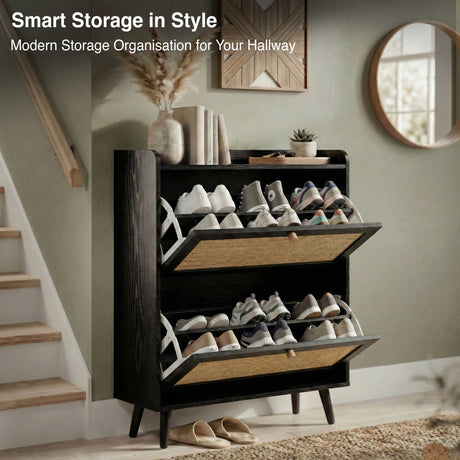 [Black] Wovena shoe cabinet with both flip drawers open showing two rows of trainers inside, styled in hallway with staircase, mirror, and decorative accessories on top