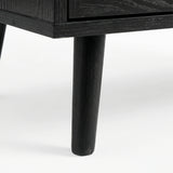 [Black] Wovena close-up of a solid tapered black-stained leg showing natural wood grain through the dark finish where it meets the ebonised cabinet base