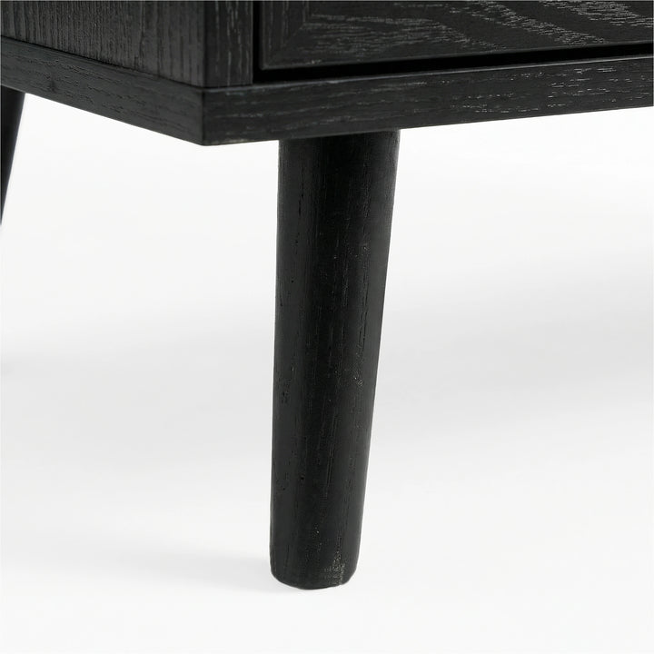 [Black] Wovena rattan TV unit leg macro, splayed black timber leg under the dark melamine cabinet edge