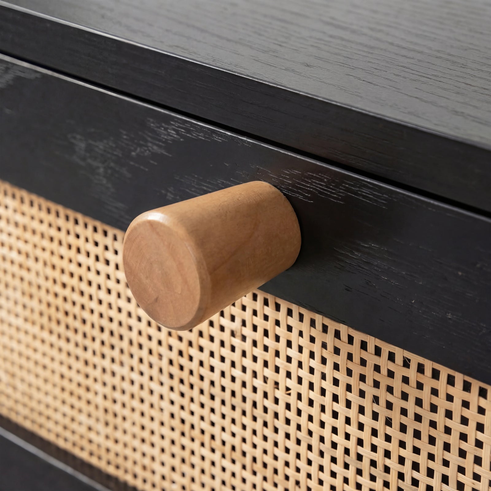 [Black] Close-up of Wovena rattan TV unit pull, light oak cylindrical knob screwed into the dark stained door rail
