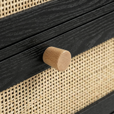 [Black] Wooden drawer knob close-up on Wovena furniture with natural cane weave pattern behind