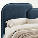 Close view of blue upholstered split headboard surface showing fabric weave and softly curved outline