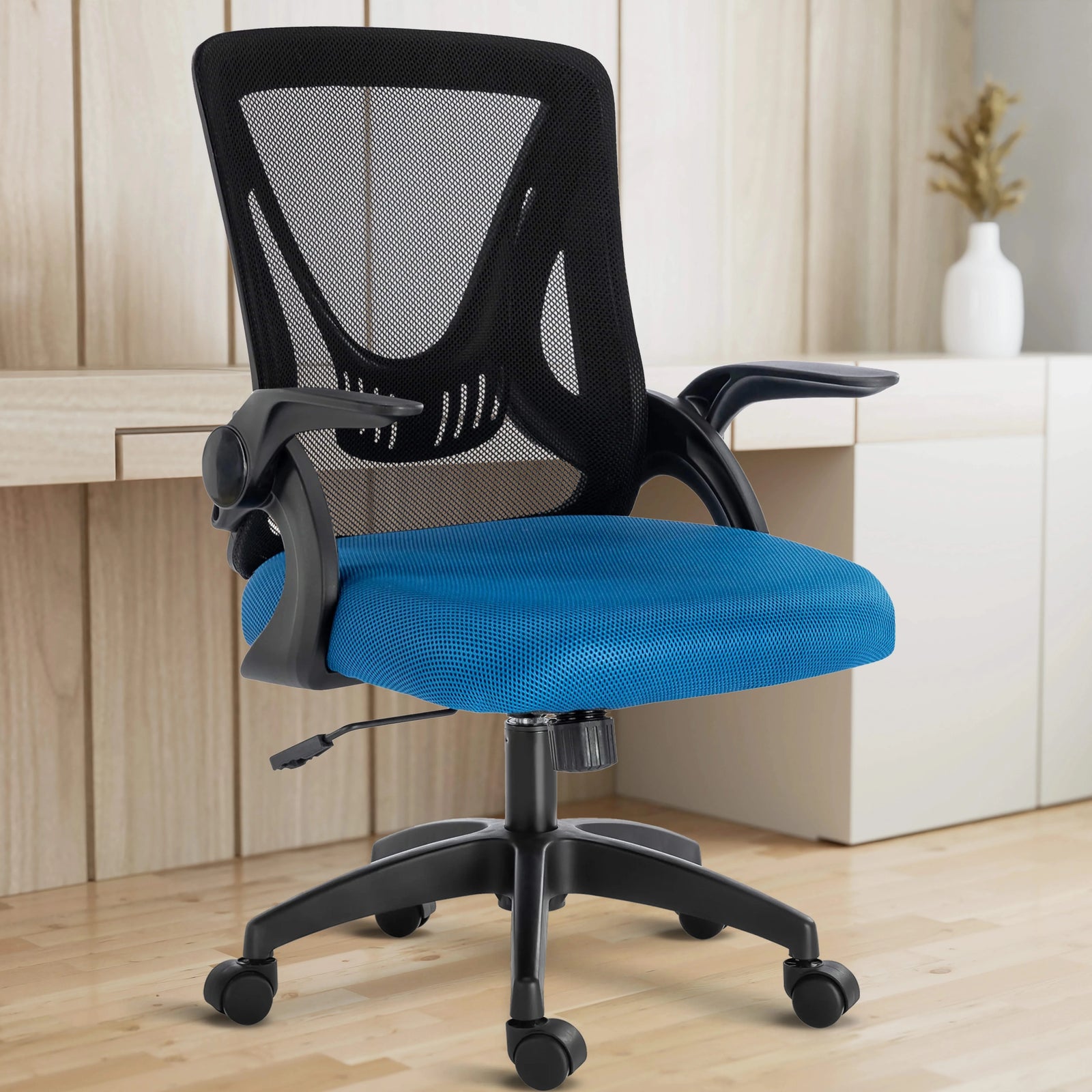 [Black+ Blue] The black and blue mesh chair is set in a home office, with the working desk behind it for ergonomic work comfort.