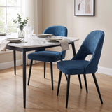 [Blue | Set of 2] Pair of fabric dining chairs at a marble-effect table styled with plates, glasses & a vase.