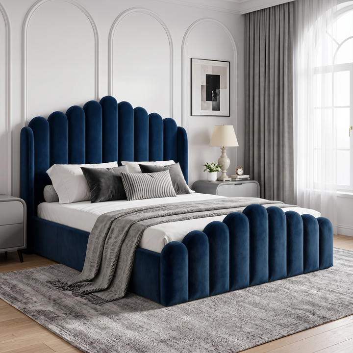 [Double | Blue] Blue velvet ottoman storage bed in a bedroom, with scalloped headboard, matching footboard and bedside lamp