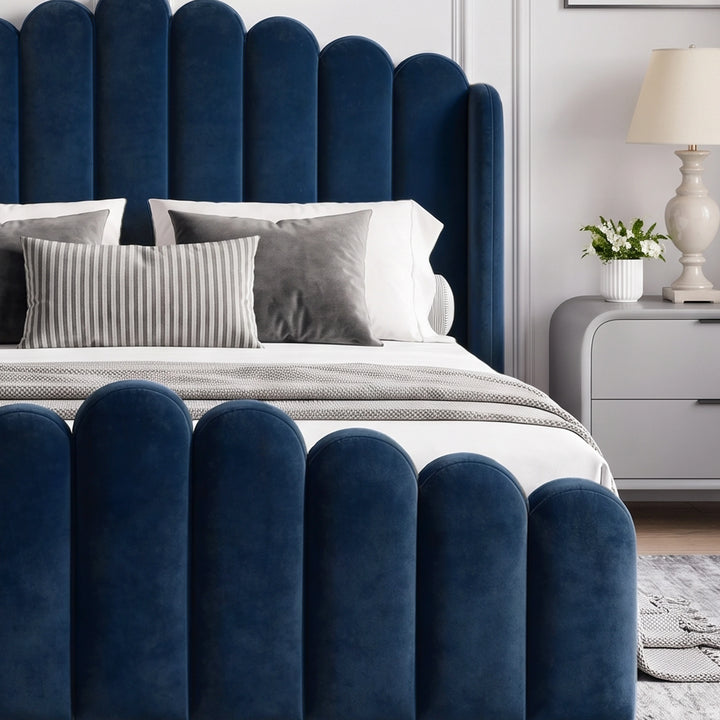 [Double | Blue] Close-up of scalloped blue velvet footboard and headboard with grey and white pillows
