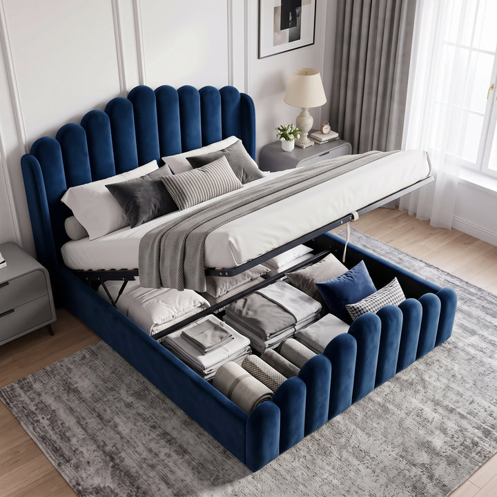 [Double | Blue] Blue velvet ottoman bed with the base lifted, showing gas-lift storage filled with folded bedding