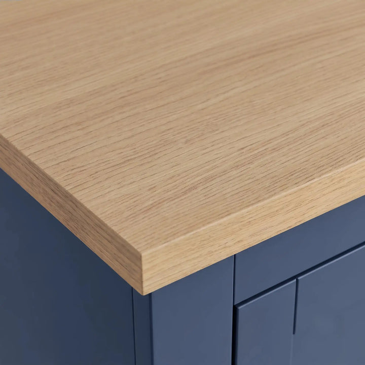 [Blue] Close-up of a wardrobe showing an oak wood-veneer top with a dark navy blue cabinet base.