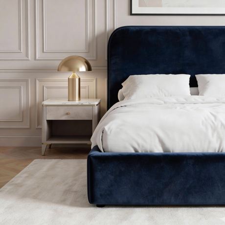 Side view of blue velvet double bed with upholstered base, low frame design and smooth fabric finish