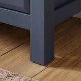 [Blue] Haven chest close-up of the solid square navy painted leg resting on warm straight oak plank floorboards