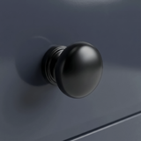 [Blue] Haven close-up of matte black round drawer knob set against navy blue painted drawer front
