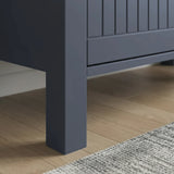 [Blue] Close-up of a dark blue wooden cabinet leg on a wooden floor