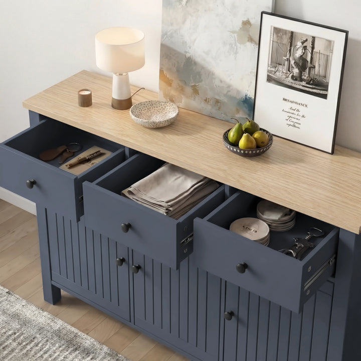 [Blue] sideboard with open drawers in a room with a lamp, decor items, and a painting