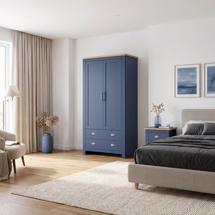 [Blue] wardrobe with a oak wood veneer top and silver handles, shown in a styled bedroom next to a bed and nightstand.