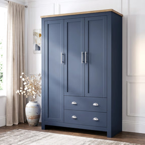 [Blue] Shaker triple wardrobe in navy blue with oak top, three panelled doors and two base drawers, angled view.