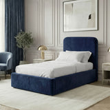 Angled room view of blue velvet single ottoman storage bed highlighting padded headboard and frame design