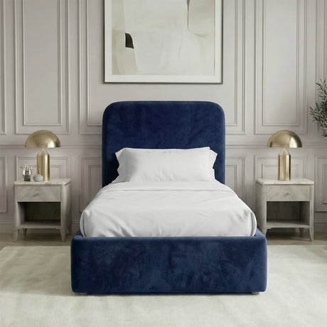 Front view of blue velvet single ottoman bed positioned between bedside tables in a neutral interior
