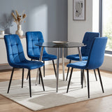 [Blue | Set of 4] Velvet dining chairs around a round black table, with curved tufted backs, padded seats and black legs.
