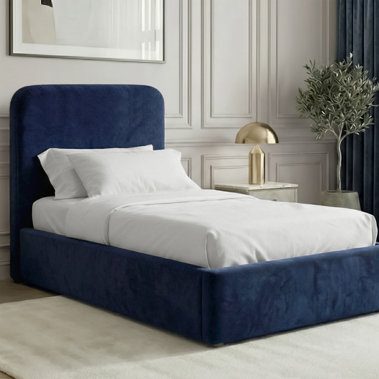 Blue velvet single ottoman storage bed placed in a bright interior with an upholstered frame and a padded headboard