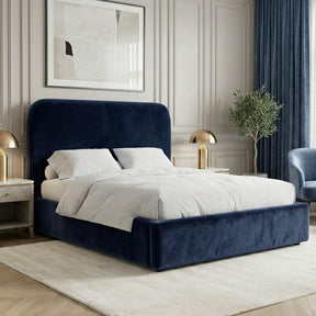 Blue velvet small double ottoman storage bed placed in a bright interior with a padded headboard and upholstered base