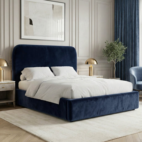 Blue velvet small double ottoman storage bed placed in a bright interior with a padded headboard and upholstered base