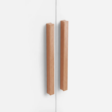 [White] Close-up of two vertical wooden handles on white Blythe wardrobe doors