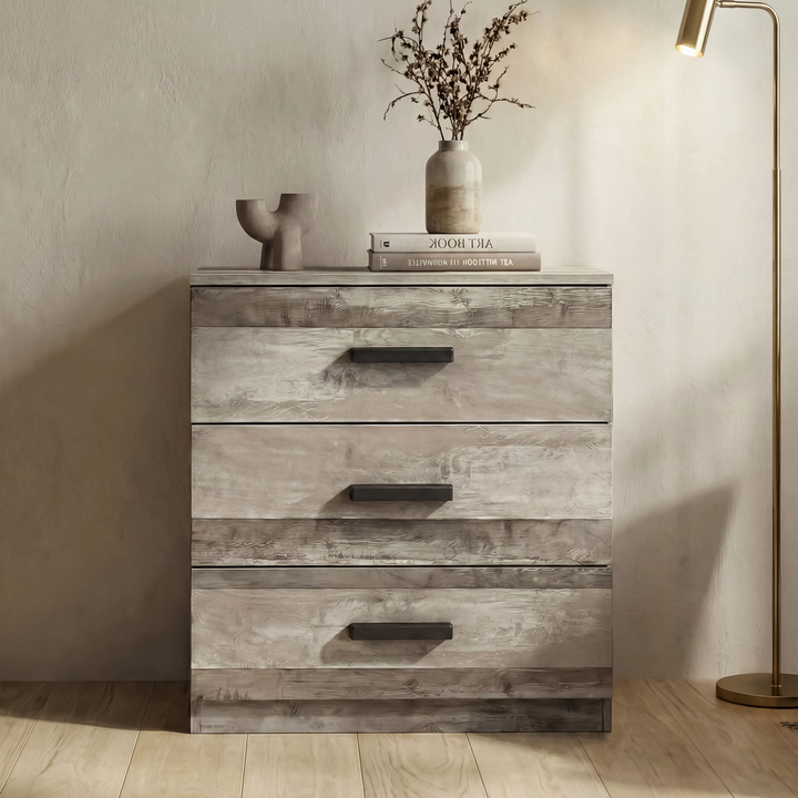 [Ash Grey] Chest piece of the Blythe bedroom furniture set shown head on against a neutral wall with floor lamp