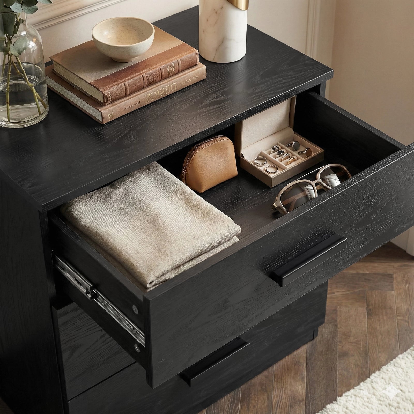 [Black] Close-up of the Blythe bedroom furniture set chest top drawer open with folded blanket and jewellery tray