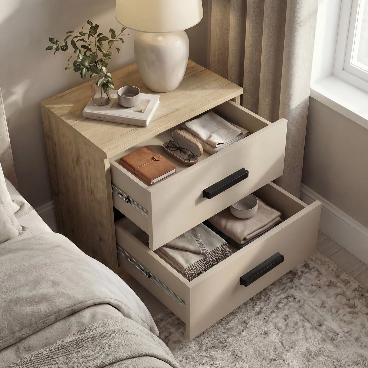 [Oak Cashmere] Bedside of the Blythe bedroom furniture set open beside a bed with oak top and cashmere fronts
