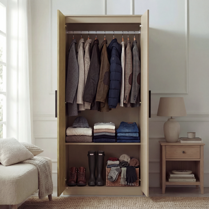 [Oak Cashmere] Wardrobe of the Blythe bedroom furniture set open with oak interior, coats on rail and boots below