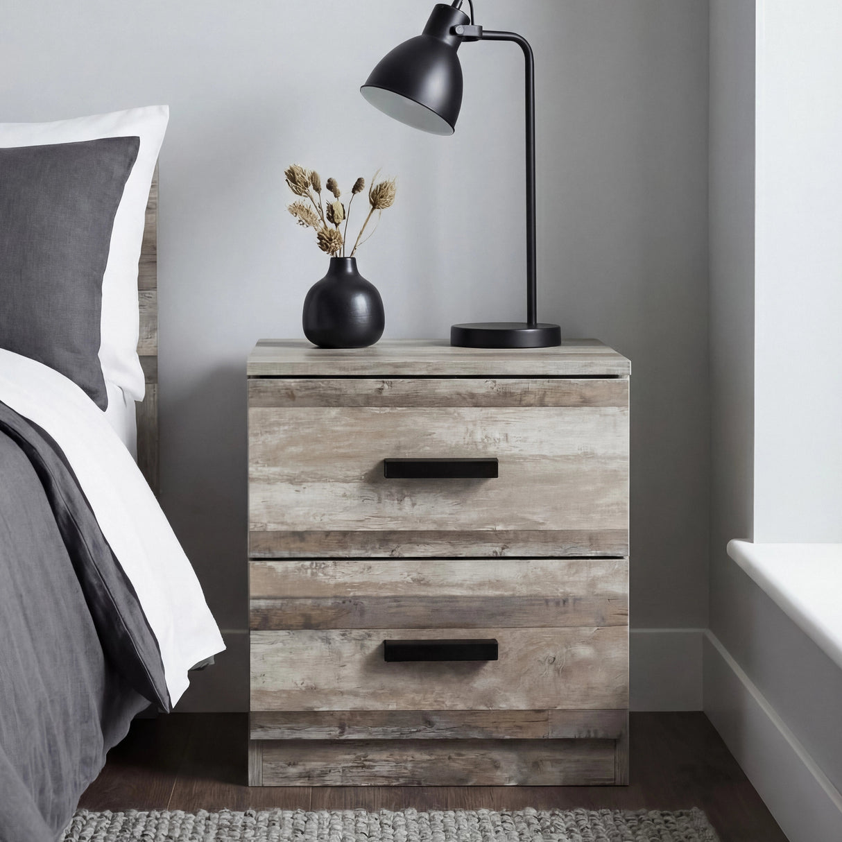 [Ash Grey] Bedside table in use beside bed showing natural wood grain texture with black bar handles and lamp
