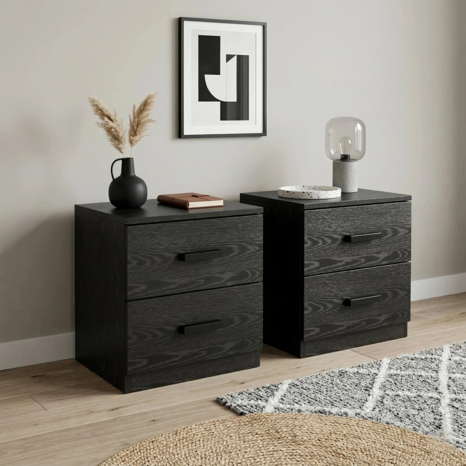 [Black] Side angle of bedside table pair showing wood grain texture and bar handles with pampas vase and dome lamp on top