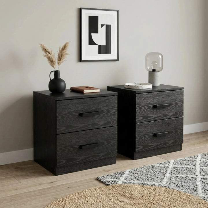[Black] Side angle of bedside table pair showing wood grain texture and bar handles with pampas vase and dome lamp on top