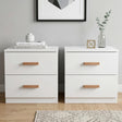 [White] Front view of white bedside table pair with oak bar handles styled with glass vase and design books on top