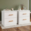 [White] Front three quarter view of two white bedside tables on woven rug with dried stems in vase and books on top